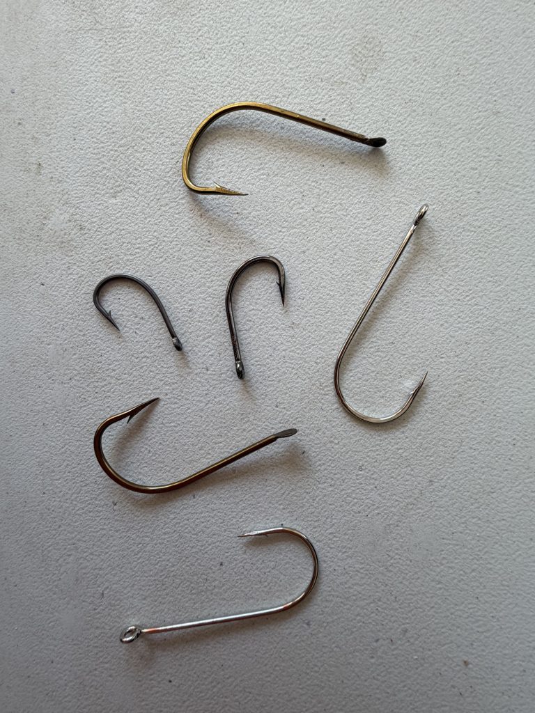 Gold, silver and dark fishing hooks showing different hook finishes