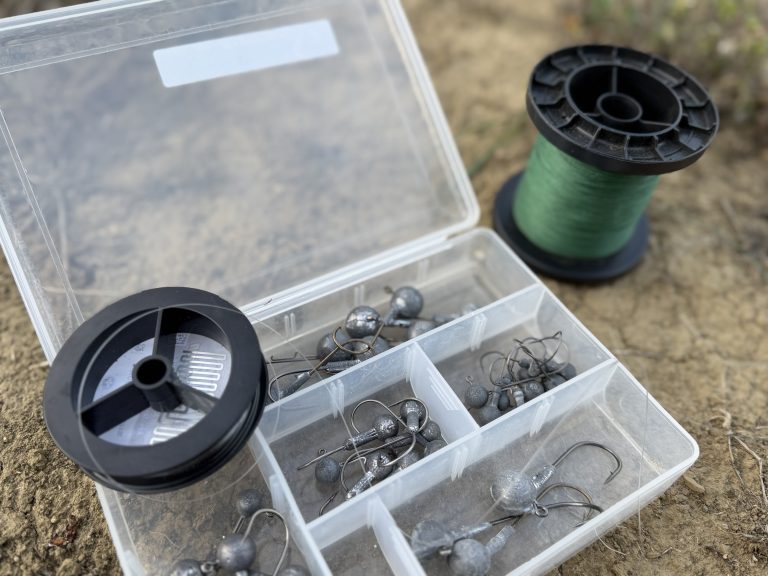 Fishing line spools and assorted jig heads illustrating what pound test for walleye jigging works best